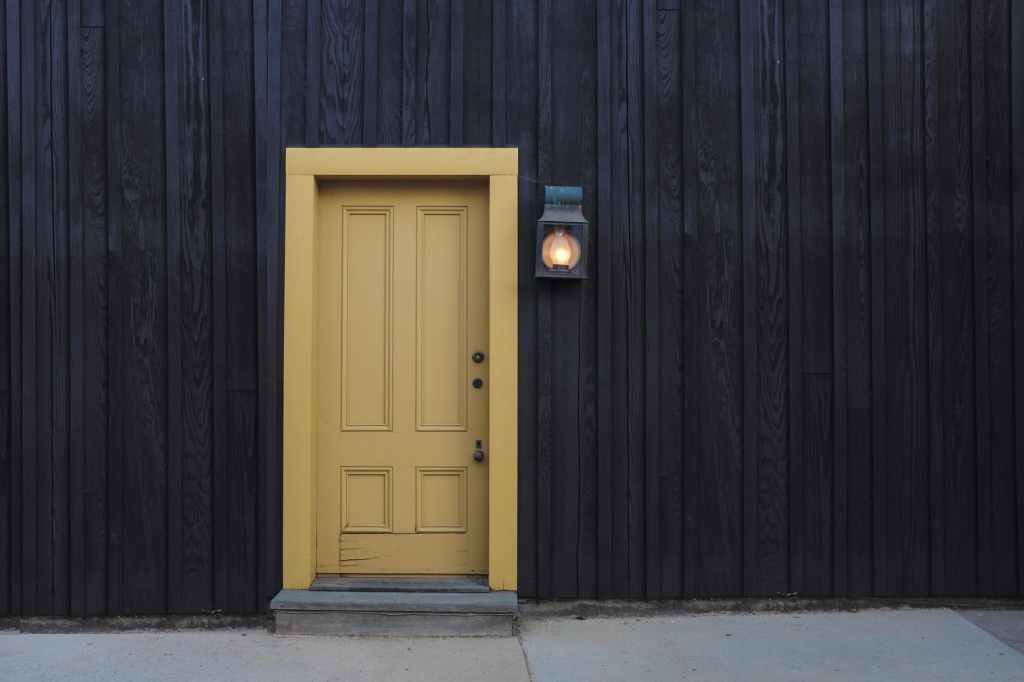 A yellow painted door neatly fixed in a building